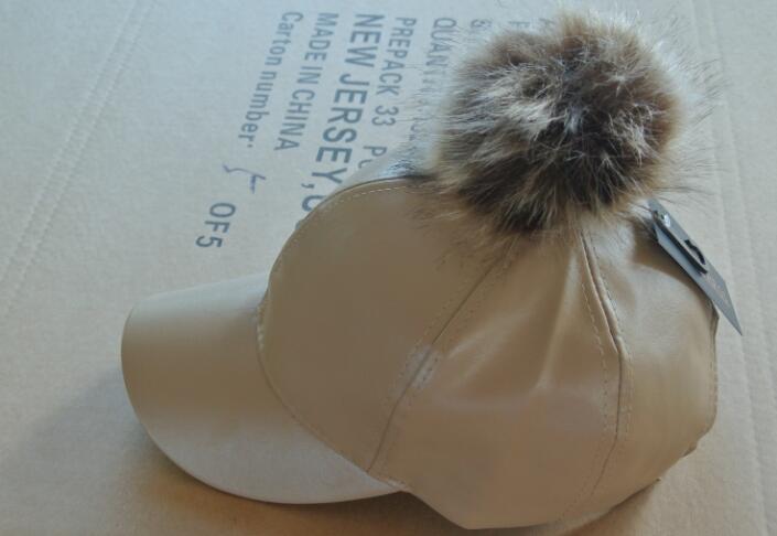 leather cap with pom pom